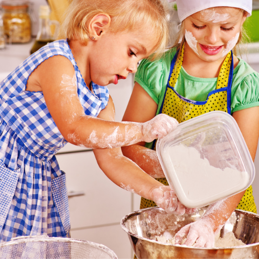 Niños cocinando, manchados de harina