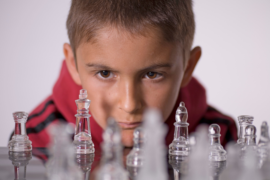 niño concentrado jugando al ajedrez